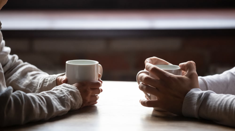 two people drinking coffee and talking