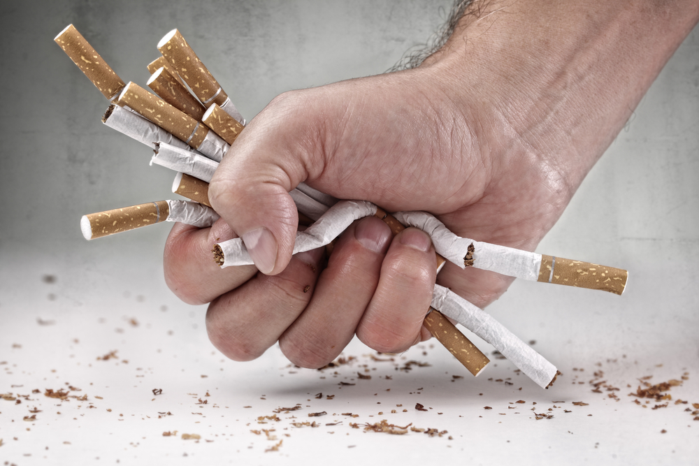 male hand crushing cigarettes